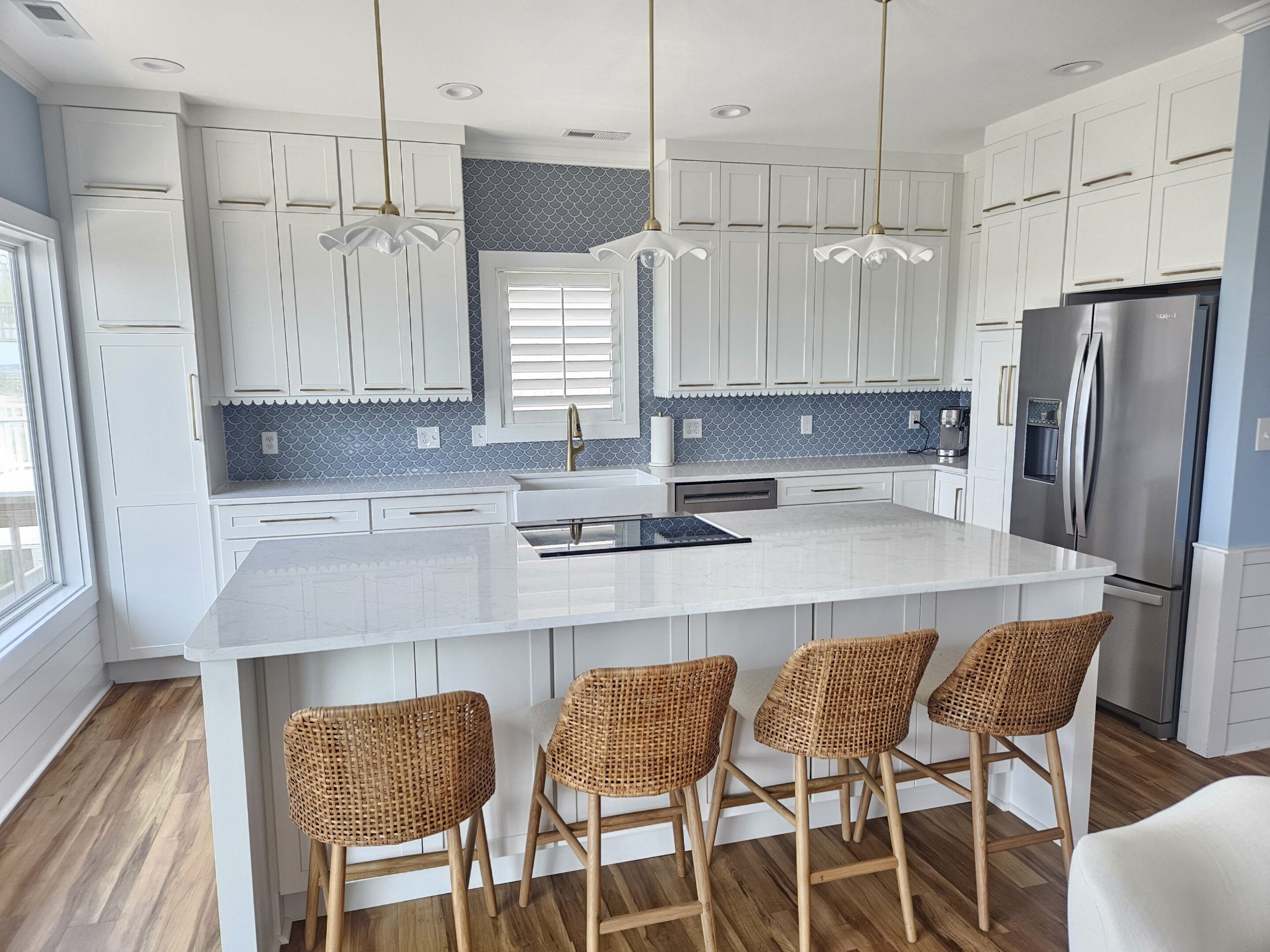 Modern white kitchen island with wicker stools