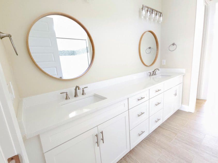 White vanity and round mirrors