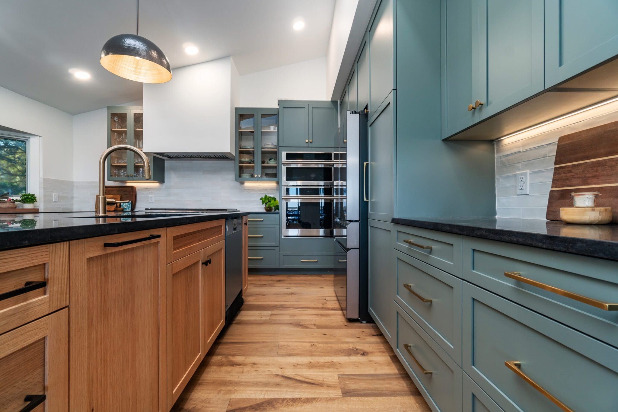 Modern kitchen with wooden and teal cabinets.