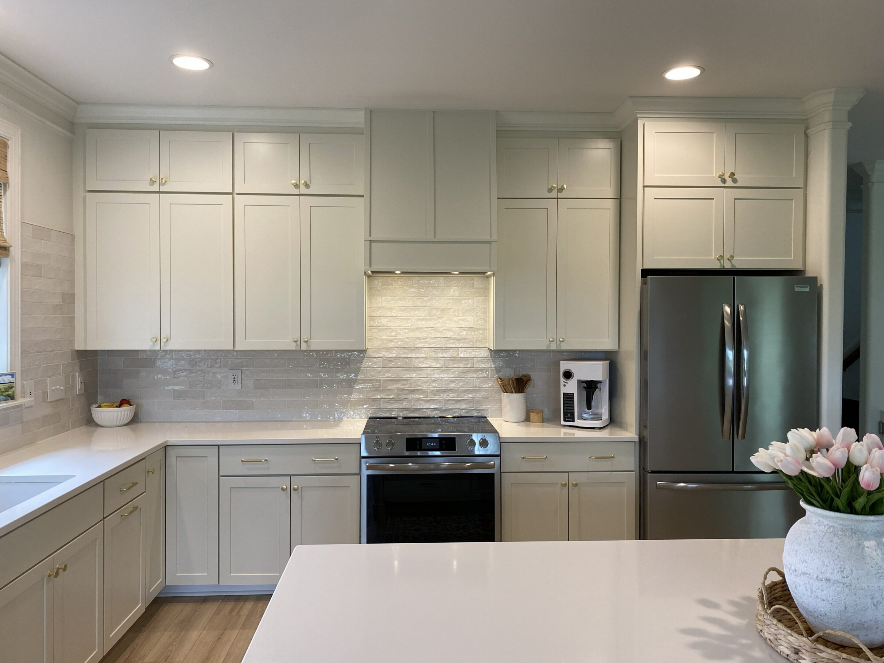Bright kitchen featuring stainless steel fridge.